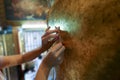 Gilding a gold leaf on the back of buddha stature