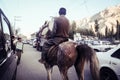 A man riding a horse along the road in Skardu city.