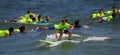 Kids in neon green shirts riding on waves while surfing at Bunger Summer Surf Camp at Gilgo Beach on Long Island