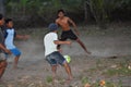 GILI ASAHAN, INDONESIA - AUGUST, 22 2016 - boys are playing soccer at sunset on a palm tree field near the beach