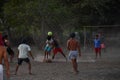 GILI ASAHAN, INDONESIA - AUGUST, 22 2016 - boys are playing soccer at sunset on a palm tree field near the beach Royalty Free Stock Photo