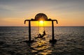 Gili Trawangan, Indonesia - September 11, 2017: Silhouette of Beautifull Gate with girls swing above ocean sunset. Gili