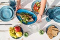 Gilt-head bream also known as Orata grilled on a barbeque grill served by a woman on a white wooden table with vegetable salad and Royalty Free Stock Photo