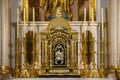 A gilt reliquary lavishly decorated in gold, inside a Catholic church
