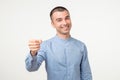 Gimme geture. Young hispanic man doing fist bump on white studio shoot