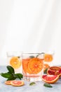 Gin and tonic alcohol drink with blood Sicilian oranges and ice on blue concrete background. Cold refreshing cocktail