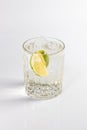 Gin and tonic cocktail in a deep glass, garnished with lime and ice. Isolated on white background Royalty Free Stock Photo