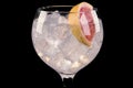 Gin tonic cocktail in glass with ice cubes and slice red grapefruit with bubbles Royalty Free Stock Photo