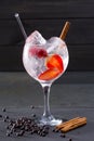Gin tonic cocktail with strawberries cinnamon and juniper