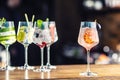 Gin tonic cocktails in wine glasses on bar counter in pup or restaurant