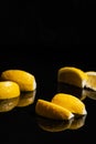 Gin tonic with lemon slices and ice cube, with lemon and ice for decorate on back, on the black background