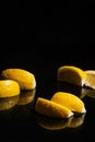 Gin tonic with lemon slices and ice cube, with lemon and ice for decorate on back, on the black background