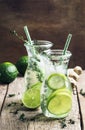Ginger ale with lime, herbal cold summer drink with thyme and ice, vintage wooden table background, selective focus