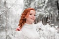 Ginger beautiful female in white sweater in winter forest. Snow december in park. Portrait. Christmas cute time. Royalty Free Stock Photo