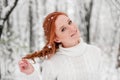 Ginger beautiful girl in white sweater in winter forest. Snow december in park. Portrait. Christmas cute time. Royalty Free Stock Photo