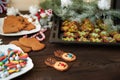 Ginger biscuits in the form of deer in aysing. Christmas tree branches on a dark wooden texture background. The concept of cooking