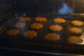 Ginger biscuits in the shape of stars are baked in the oven.