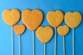 Ginger biscuits on a stick in the form of hearts on a blue background Royalty Free Stock Photo