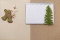 Ginger bread cookies on craft paper background . Blank notepad with leaf of fern. Simple Christmas mockup. Top view.