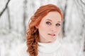 Ginger caucasian girl in white sweater in winter forest. Snow december in park. Portrait. Christmas cute time. Royalty Free Stock Photo