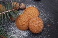 Ginger Christmas cookies on a black board with sugar powder and fir branch. Cooking recipie.