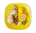 Ginger, cinnamon, lemon, garlic and cloves on the yellow plate
