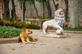 A ginger dog rests near the statue of a lion in Gulhane park. Istanbul