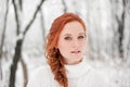 Ginger european girl in white sweater in winter forest. Snow december in park. Portrait. Christmas cute time.