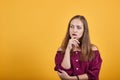 Ginger girl in burgundy bluse with bow over orange background t Royalty Free Stock Photo