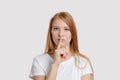 A ginger girl with a finger in front of her lips Royalty Free Stock Photo