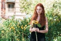 Cute ginger girl posing with sunflower outdoor Royalty Free Stock Photo