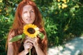 Ginger girl posing with sunflower outdoor Royalty Free Stock Photo