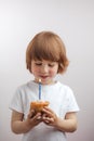 Ginger good looking boy is making a wish in front of the cup cake