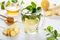 Ginger green tea in a glass for flu cold winter days. Side view on white wooden background decorated with mint, lemon Royalty Free Stock Photo