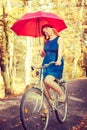 Ginger hair girl is holding red umbrella.