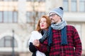 Ginger hair woman stoped man in glasses to ask the way