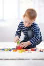 Ginger-haired little boy playing at home