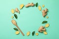 Ginger, leaves and spoon with ginger powder on mint background