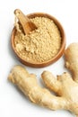 Ginger powder in a wooden bowl and a ginger root on a white background Royalty Free Stock Photo