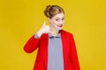 Ginger red head woman in red suit showing phone sign.