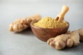 Ginger root and ginger powder in wooden bowl over grey concrete background with copy space. Immune system support Royalty Free Stock Photo