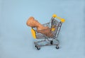 Ginger root lies in a supermarket trolley on a blue background. Useful. Spice. Health. Copy spaes