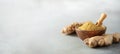 Ginger root and ginger powder in wooden bowl over grey concrete background with copy space. Immune system support Royalty Free Stock Photo