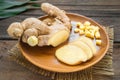 Ginger root sliced on wooden plate Royalty Free Stock Photo