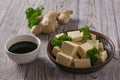 Ginger root, soy sauce and slices of tofu cheese on a wooden table. Royalty Free Stock Photo