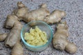 Ginger roots with diced pealed ginger in a bowl