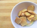 Ginger slice in white bowl on wooden background Royalty Free Stock Photo