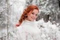 Ginger sweet girl in white sweater in winter forest. Snow december in park. Portrait. Christmas cute time. Royalty Free Stock Photo