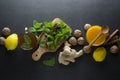 Ginger tea cup with lemons and mint leaves on dark background. Ginger tea, drink ingredients, cold and autumn time