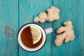 Ginger tea in a cup on wooden background